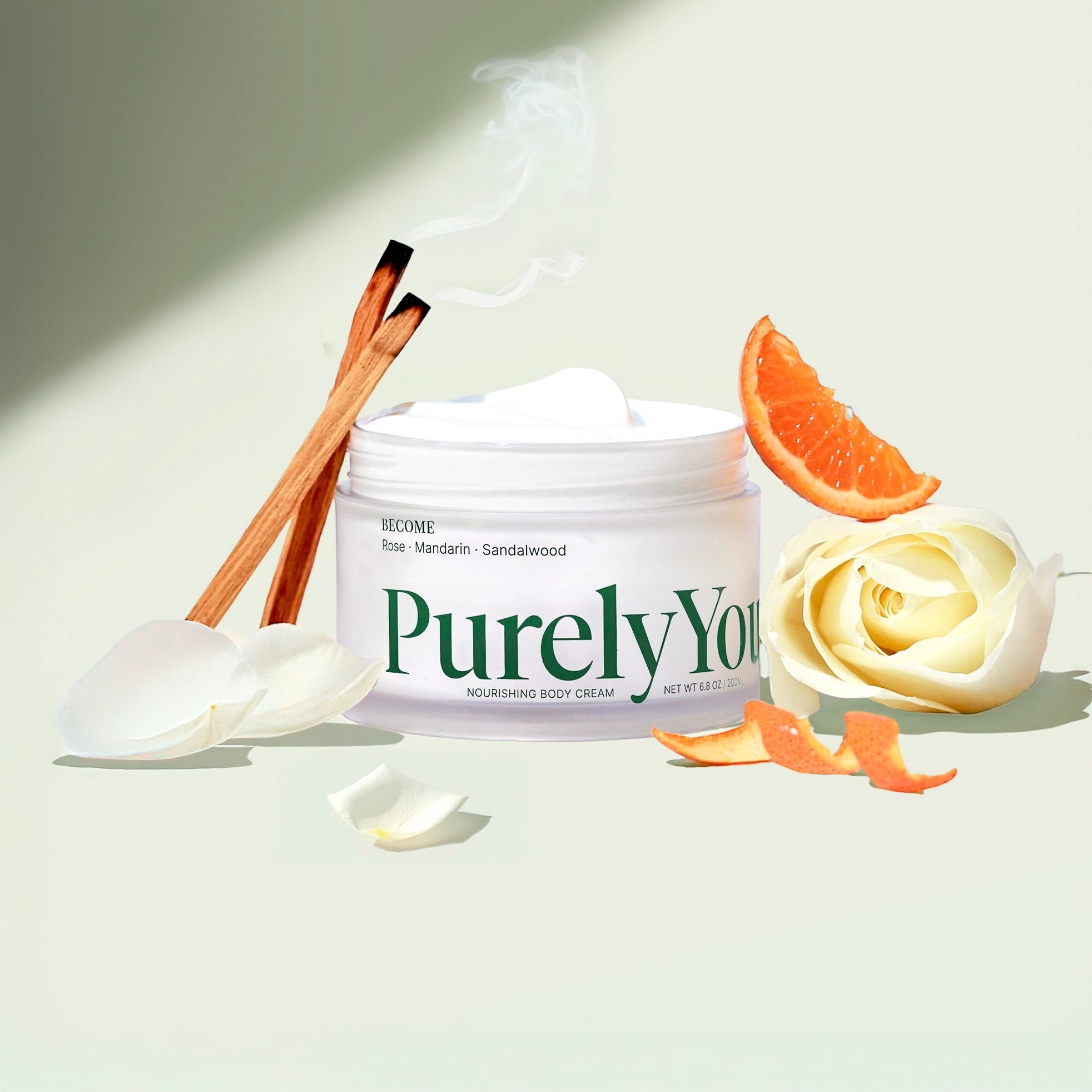 Purely You Nourishing Body Cream in a clear jar with white lid, featuring rose, mandarin, and sandalwood notes.